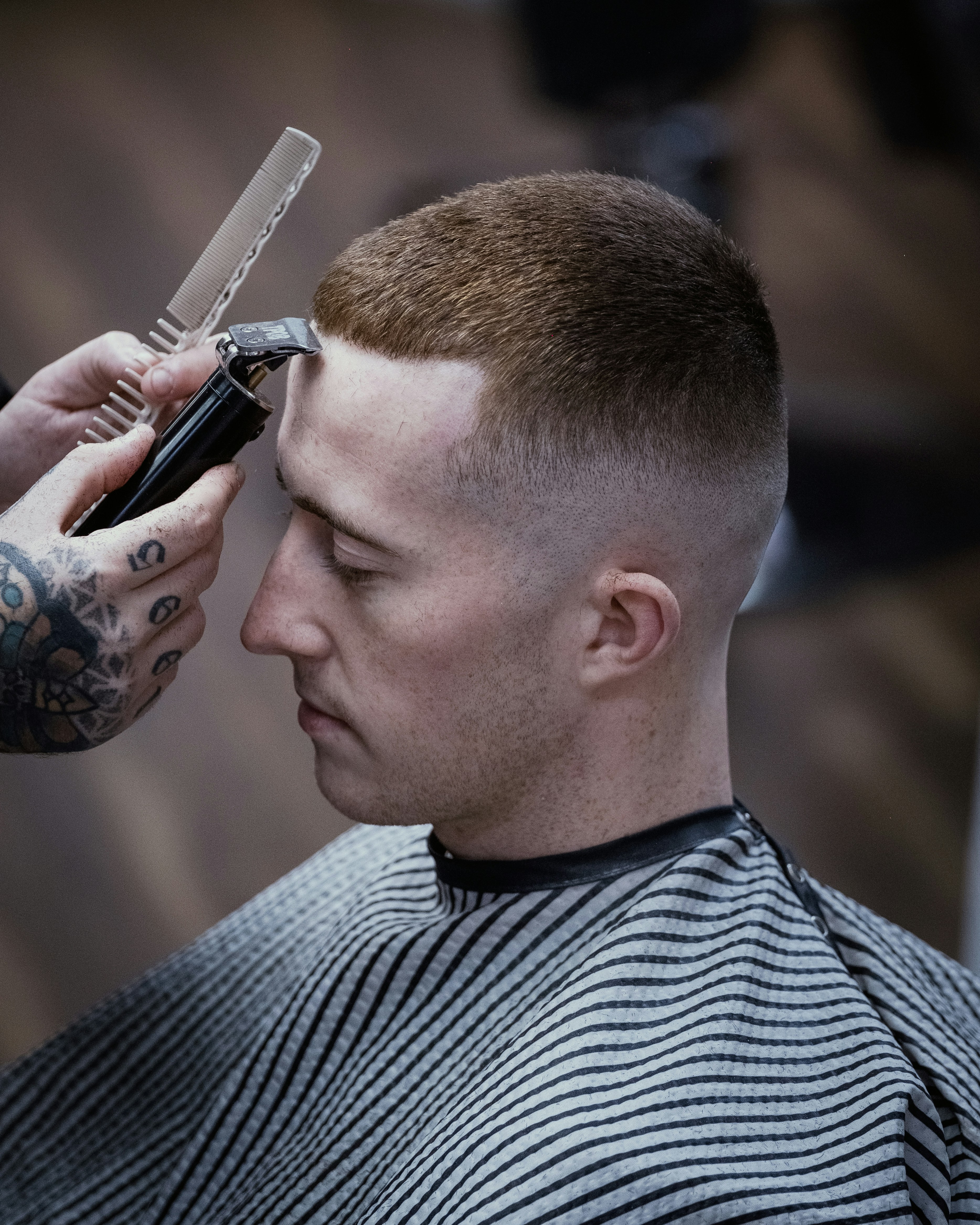 Barber trasând linia frontală a unei tunsori scurte