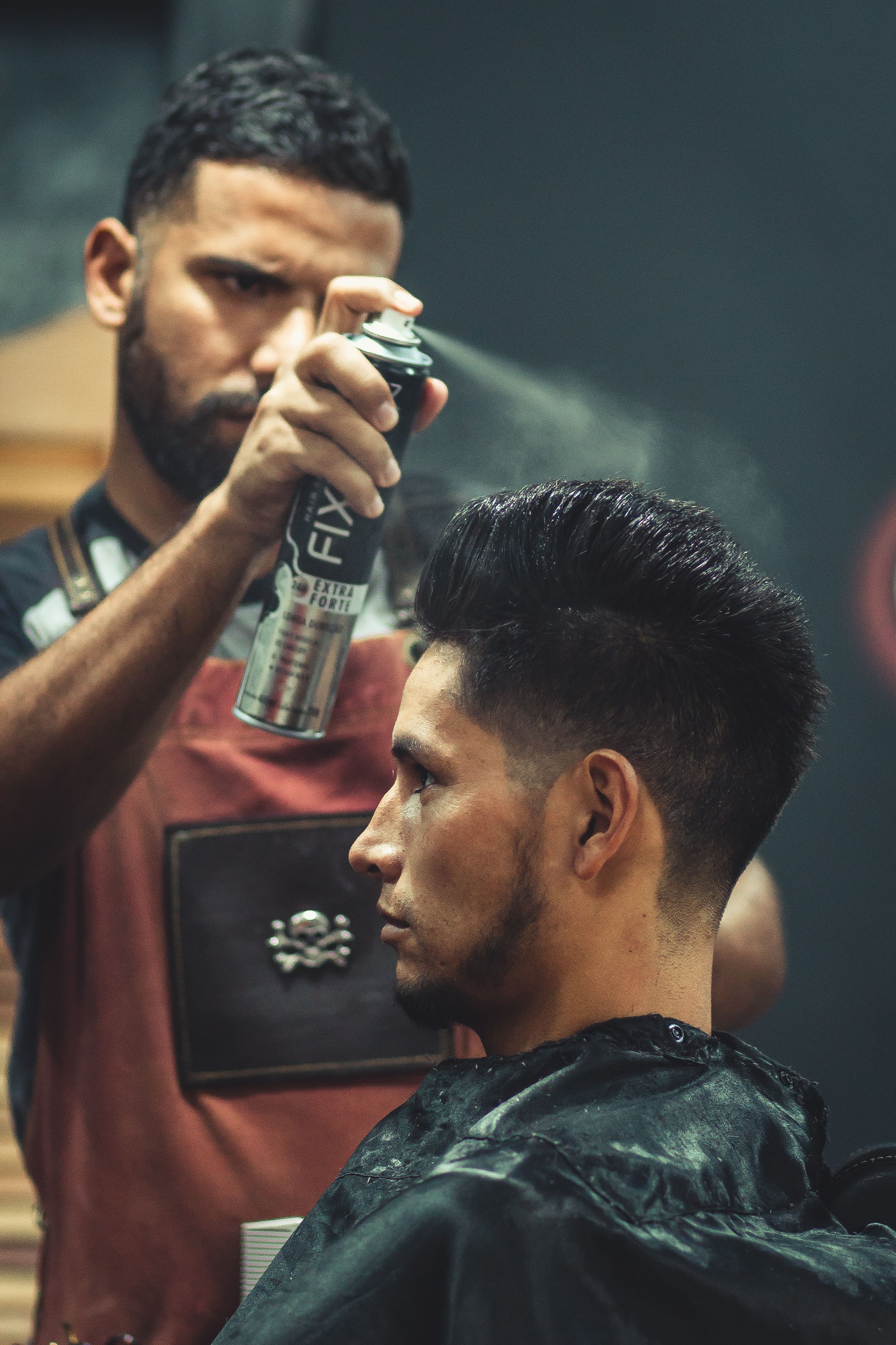 Barber aplicând produsul de styling pentru finisare